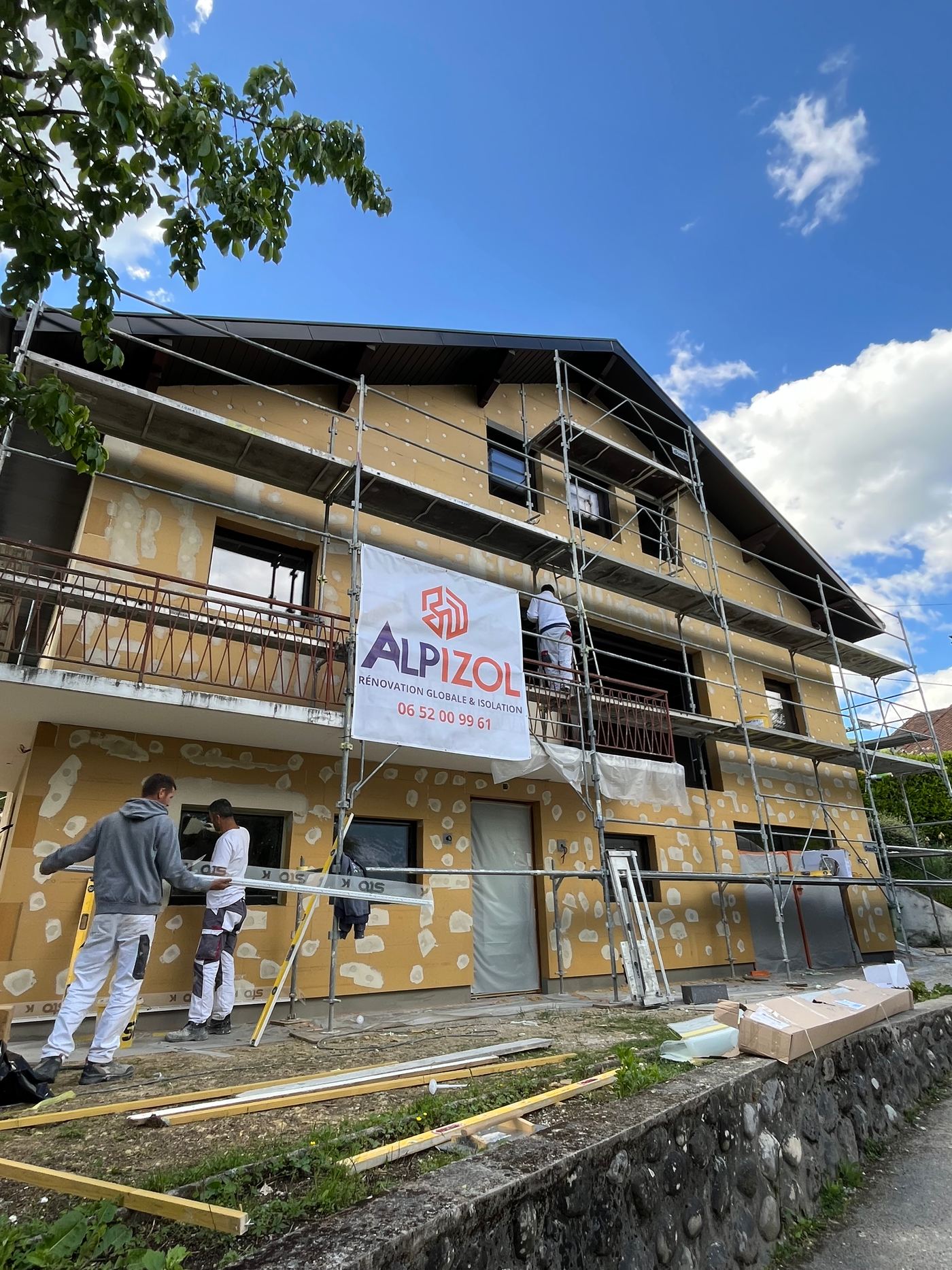 Artisan posant des panneaux isolants sur une façade Alpizol